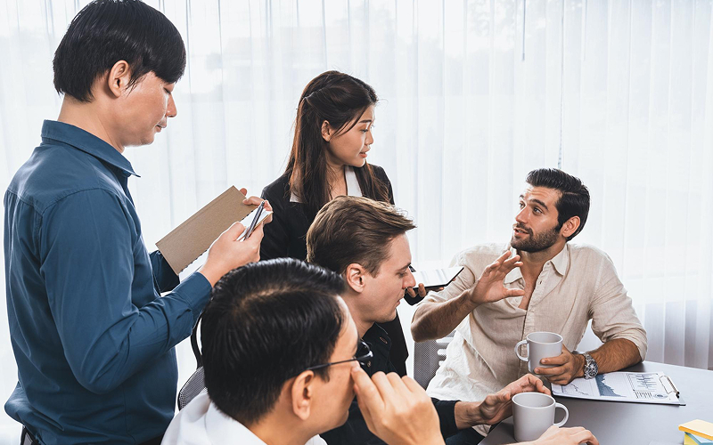 Group of people discussing documents and data in an office.